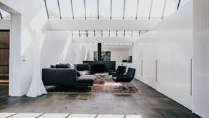 A modern interior with a living area featuring a sofa, chairs, and a fireplace. - Alkina Lodge Nuru (Wattle Hill)