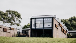 A modern building with a glass facade, brick walls, and a flat roof. - Alkina Lodge Nuru (Wattle Hill)