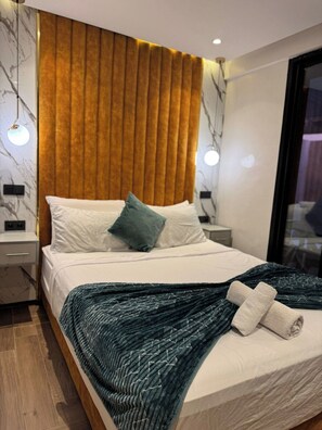 A modern bedroom with a bed, a headboard, bedside tables, and a view of the outside.
