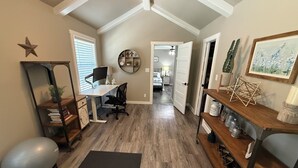 A home office with a desk, chair, and exercise ball. There is a bookshelf, a mirror, and a yoga mat. - Charming 3-bedroom house with fitness room and AC in Bandera (Bandera)