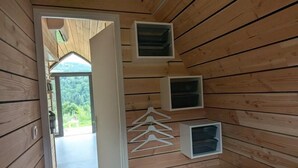 A bedroom with a bed, wooden walls, and built-in storage units. - La Cabane d'Antoine - MONT LOZERE ET GOULET (MONT LOZERE ET GOULET)