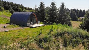 A modern, dome-shaped building with a glass entrance and a small outdoor seating area. - La Cabane d'Antoine - MONT LOZERE ET GOULET (MONT LOZERE ET GOULET)