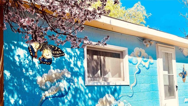 A building with a blue exterior, a window, and a door.
