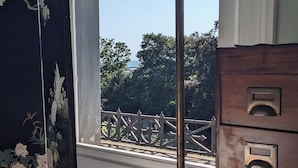 A room with a large window, a decorative floor lamp, and a wooden dresser with multiple drawers. - Huge 1 bed in Historical Garrison with Dover Castle View & Sea view. (Dover)