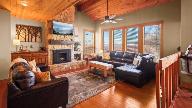 A cozy living room with a fireplace, leather sofas, and wooden floors.