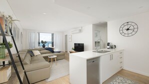 A modern apartment with a living room, kitchen, and balcony.