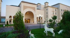 A hotel with a large entrance, arched doorway, and a central light fixture.