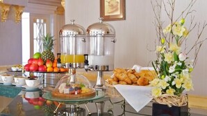 A buffet setup with a fruit display, coffee urns, and pastries. - Sunkar (Almaty)
