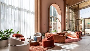 A spacious lobby with modern seating, large windows, and a view of the outside.