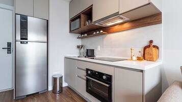 Gallery appartement | Privékeuken | Een koelkast met diepvriezer, een microgolfoven, een kookplaat