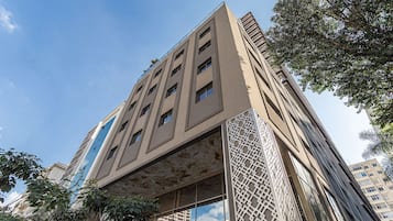 A tall building with multiple floors, large windows, and a unique facade design.