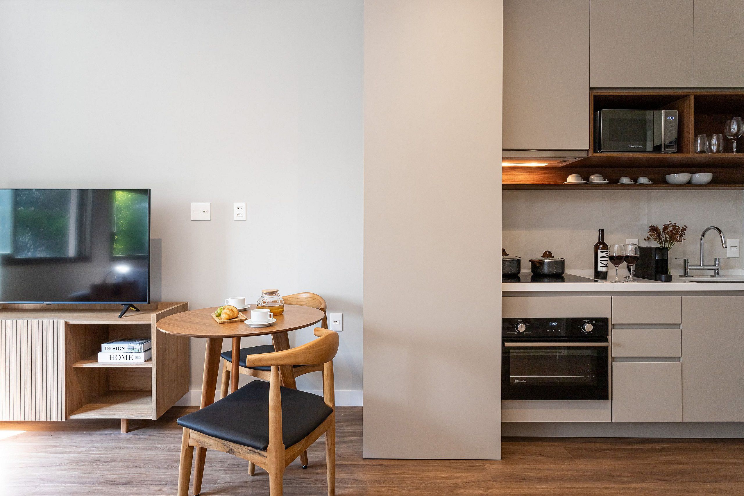 Una cocina moderna con comedor, televisor de pantalla plana y microondas.