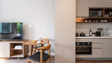 Una cocina moderna con comedor, televisor de pantalla plana y microondas.