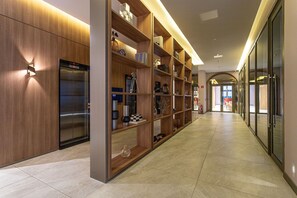 Un couloir moderne avec un mur en bois, une bibliothèque intégrée et un ascenseur visible.