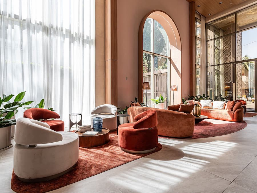 Un vestíbulo amplio con asientos modernos, ventanas grandes y vistas al exterior.