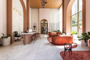 A spacious interior with a reception desk, seating area, and large windows.