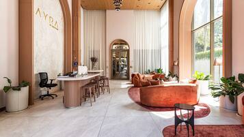 A spacious interior with a reception desk, seating area, and large windows.