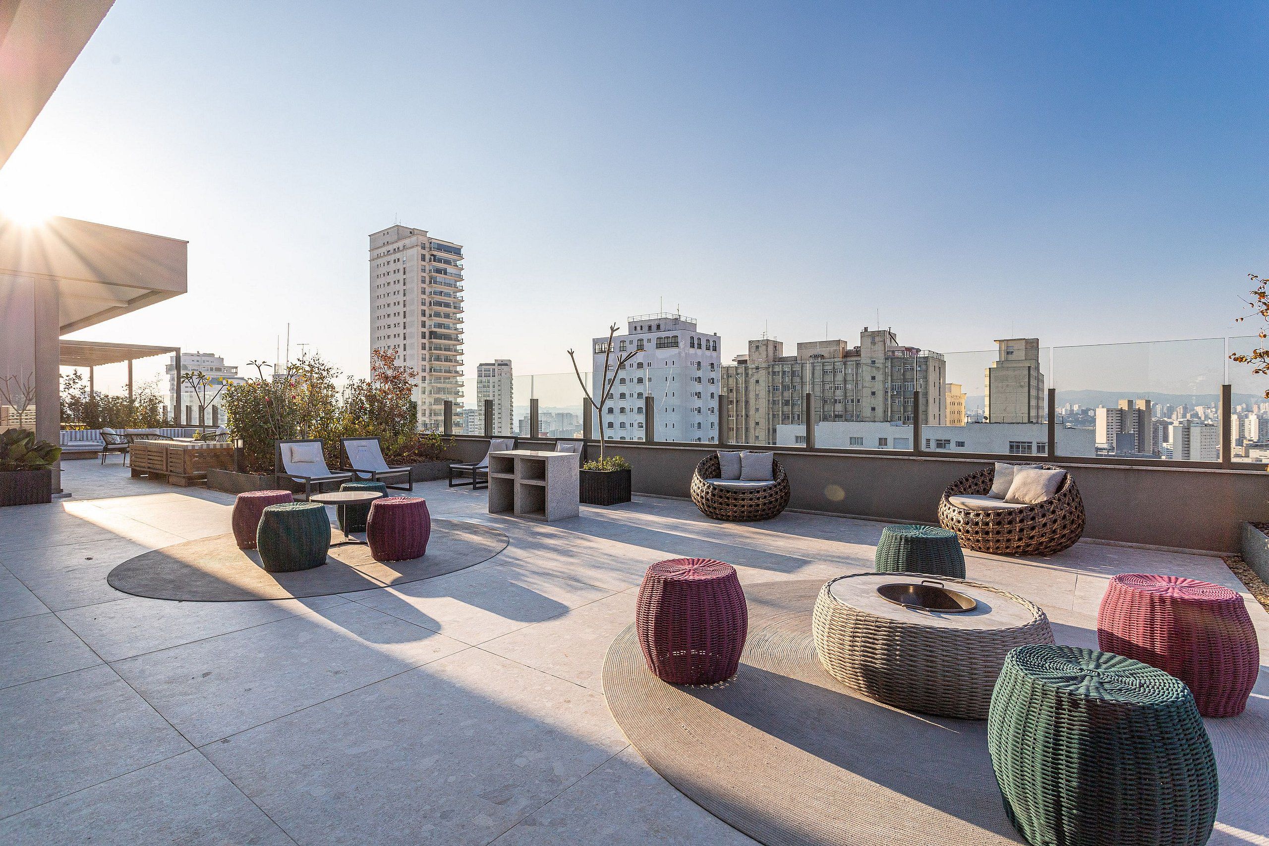 Terraço no terraço com área de estar externa, lareira e vista para o horizonte da cidade.