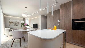 Een moderne keuken met een centraal eiland, houten kastjes en een inbouwoven.