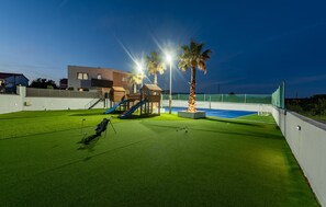An outdoor play area with artificial turf, a slide, and a small wooden structure. - Luxurious home in Vrsi with sauna (Vrsi)