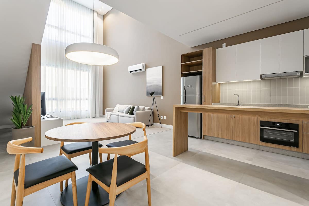 Une cuisine moderne dotée d’un îlot central, d’appareils électroménagers intégrés et d’un coin repas avec une table ronde et des chaises.