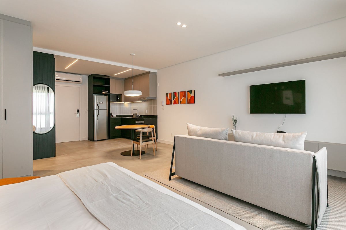 Une chambre d’hôtel moderne équipée d’un lit, d’un canapé, d’un coin repas et d’une cuisine.