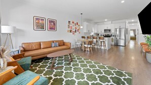 A modern apartment with a living room, dining area, and kitchen.