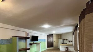 A hotel room with two beds, a kitchenette, a TV, and a bathroom. - Marvin Suites (Isla Holbox)