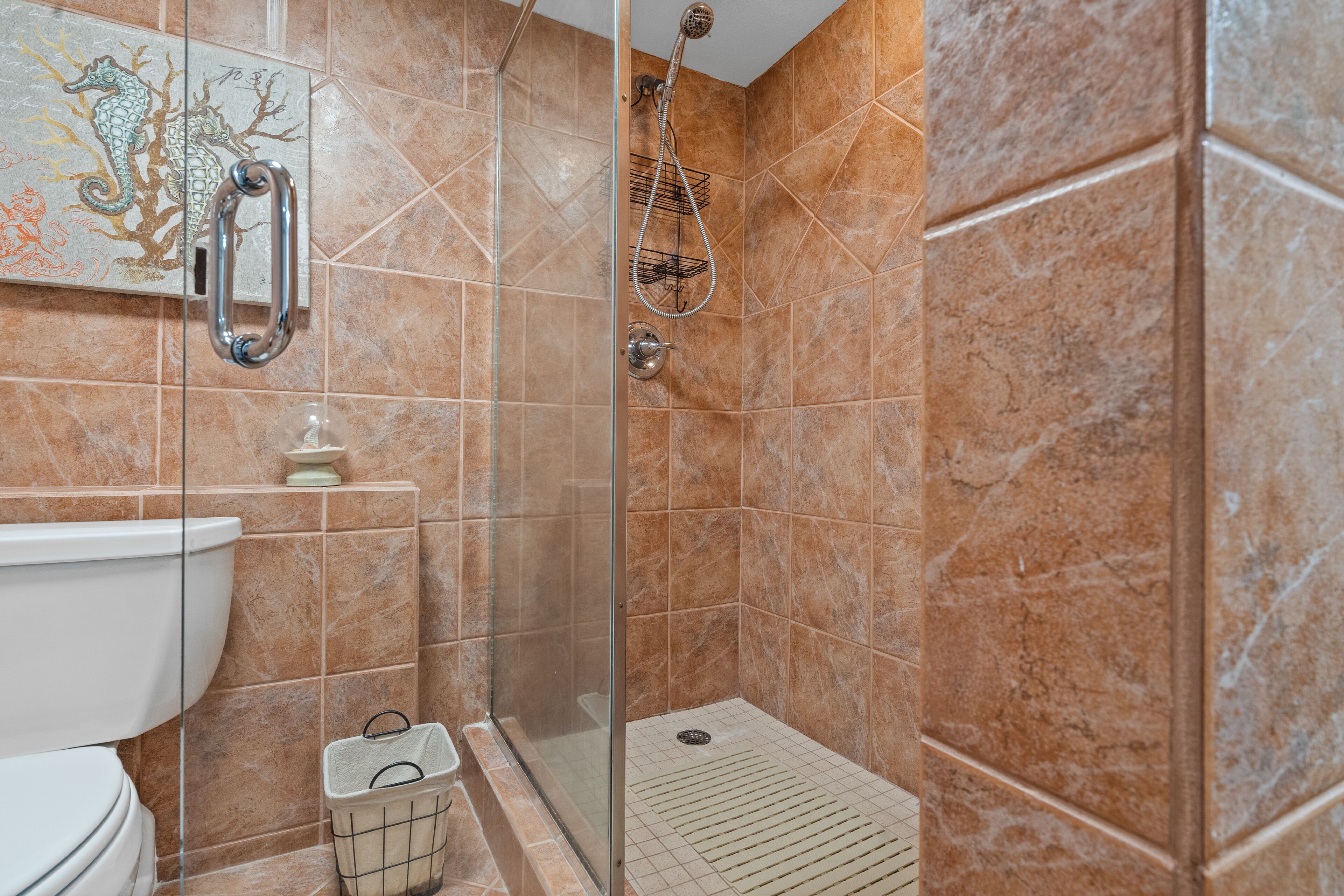 Un baño con ducha de vidrio, inodoro y lavamanos.