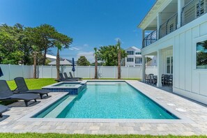 A rectangular swimming pool with a clear blue water surface, surrounded by a paved deck with lounge chairs. - New Home, Golf Cart, Walk To Beach! Private Pool! (Destin)