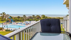 A balcony with a view of a swimming pool and beach. - Picture Perfect at Colony Reef Club 1310 (St. Augustine)