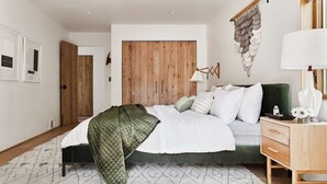 Une chambre à coucher moderne avec un lit, une table de chevet et un élément décoratif suspendu au mur.
