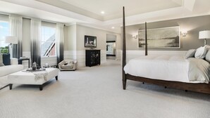 Une chambre spacieuse avec un grand lit, un coin salon avec une table basse et une vue sur un bâtiment à l’extérieur.