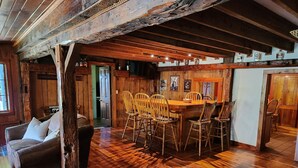 Interior rústico em madeira com área de jantar, paredes de madeira e um ambiente acolhedor.
