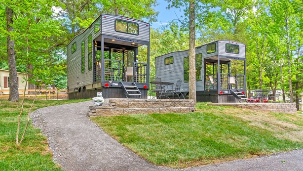 Two modern, metallic mobile homes with external staircases, set in a wooded area with a gravel path. - “Special Place”Short Term Rentals Tiny Home Springville,Tennessee 148 (Springville)