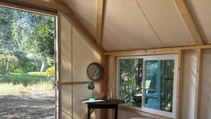 Ein gemütliches Zimmer mit einem großen Bett, einem kleinen Tisch und einem Fenster mit Blick auf einen Garten.
