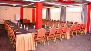Una sala de conferencias con una larga mesa, sillas y una pizarra.