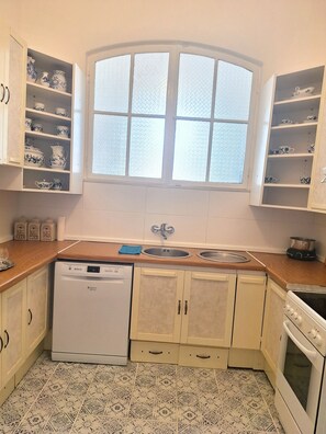 Uma cozinha compacta com lava-louças, pia dupla e fogão.