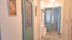 A hallway with patterned doors, a white dresser, and a tiled floor. - 4-bedroom apartment in Karlovy vary (Karlovarský kraj)
