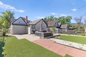 Una propiedad residencial con patio, mobiliario exterior y césped bien cuidado.