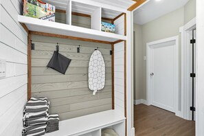 Een kamer met een houten wand, een witte plank met een surfplank, een handdoek en een doosje met de tekst 'AWN DARTS'.