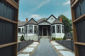 A two-story house with a number '544' on the front door, a covered porch, and a pathway leading to the entrance.