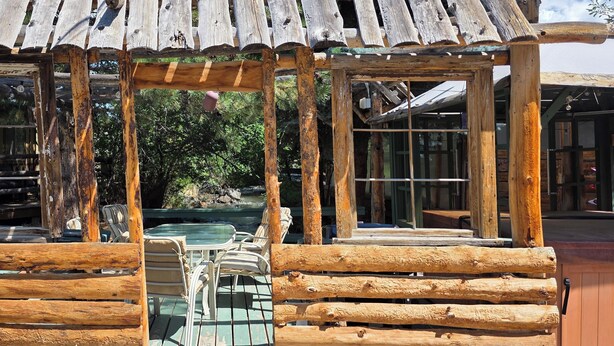 A rustic wooden structure with a glass door and a small pool area. - Modern Suite with Rustic Charm Dog Friendly Suite with King Bed and Full Kitchen (Cedaredge)