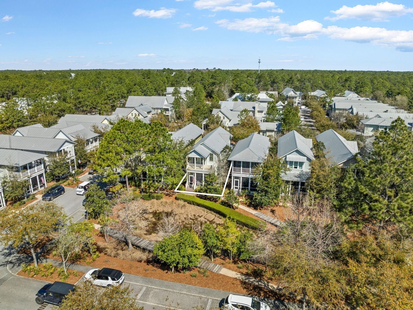 A residential area with multiple houses, a clear sky, and a distant communication tower.