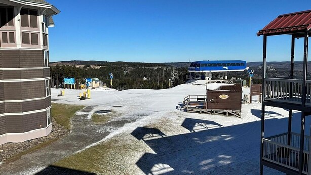 Ein Skigebiet mit Berghotel, blauem Bus und verschneiter Landschaft.
