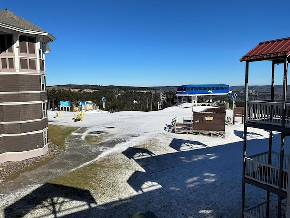 Ein Skigebiet mit Berghotel, blauem Bus und verschneiter Landschaft.