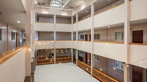 Ein mehrgeschossiges Hotelinnere mit Balkonen, Lichterketten und einem zentralen, offenen Bereich.