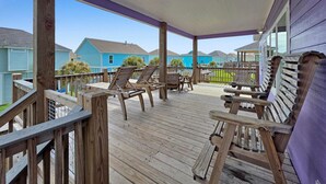 Una terraza de madera con mobiliario exterior y un espacio cubierto.