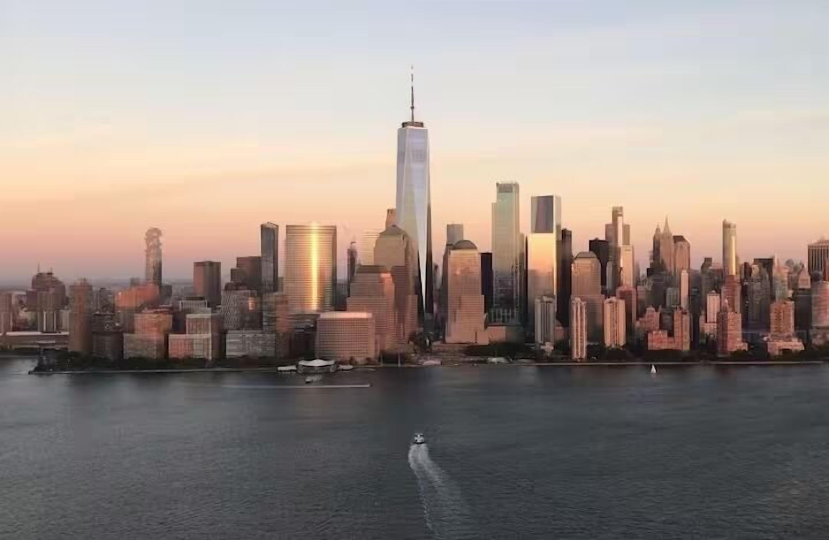 Stadszicht met een opvallend wolkenkrabber, vermoedelijk One World Trade Center, en een wateroppervlak op de voorgrond.
