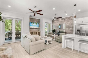A spacious living area with a sofa, coffee table, and a kitchen island with seating.